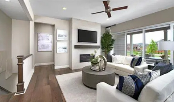 Living room featuring dark hardwood / wood-style floors and ceiling fan. Photos are of a Decker plan but not the subject property.