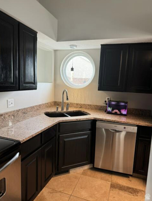 Kitchen with light tile patterned floors, stainless steel appliances, and sink