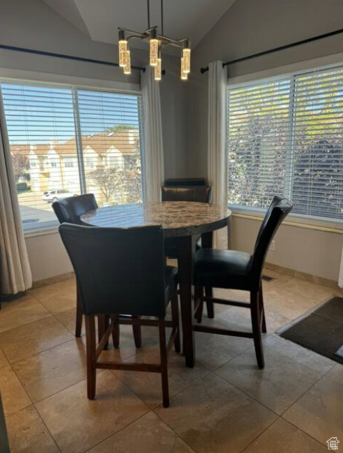 Tiled dining room featuring lofted ceiling