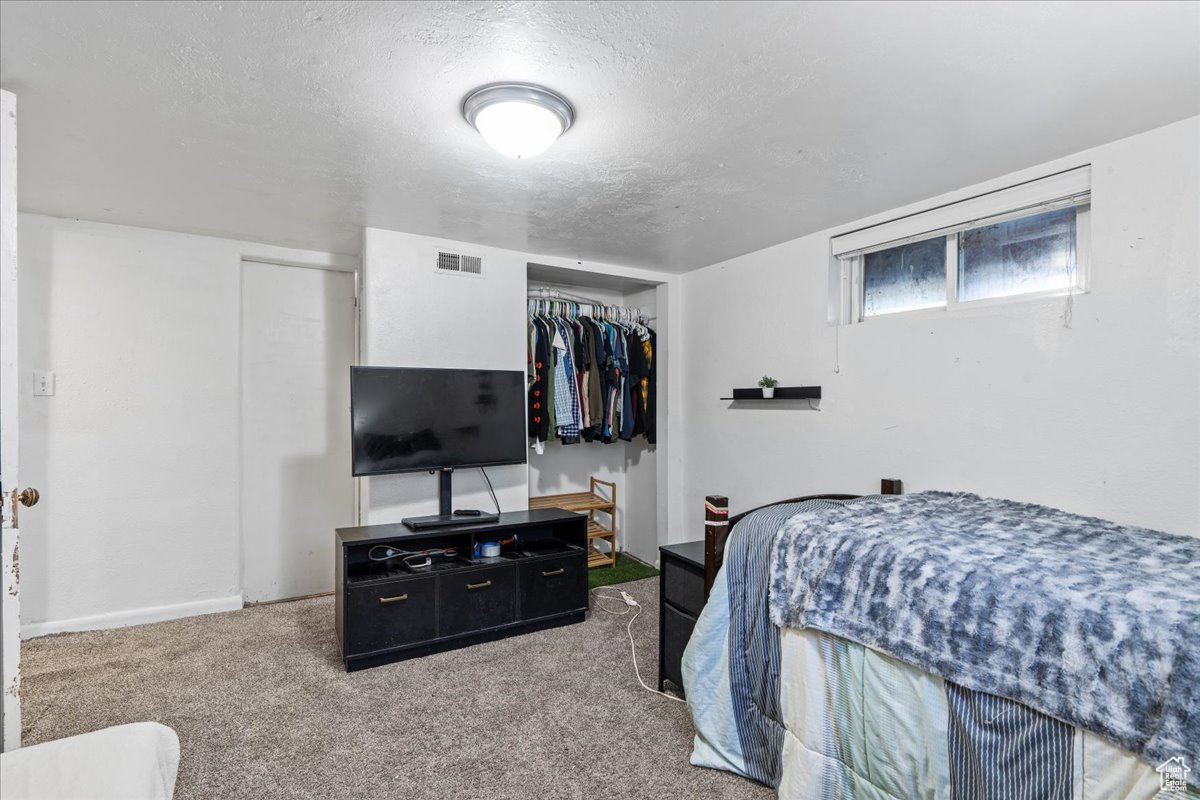 Bedroom with a closet, a textured ceiling, and carpet floors