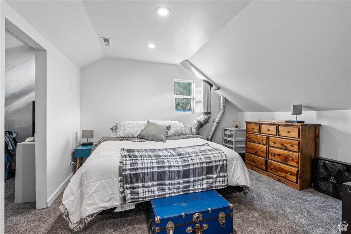 Bedroom with carpet and lofted ceiling