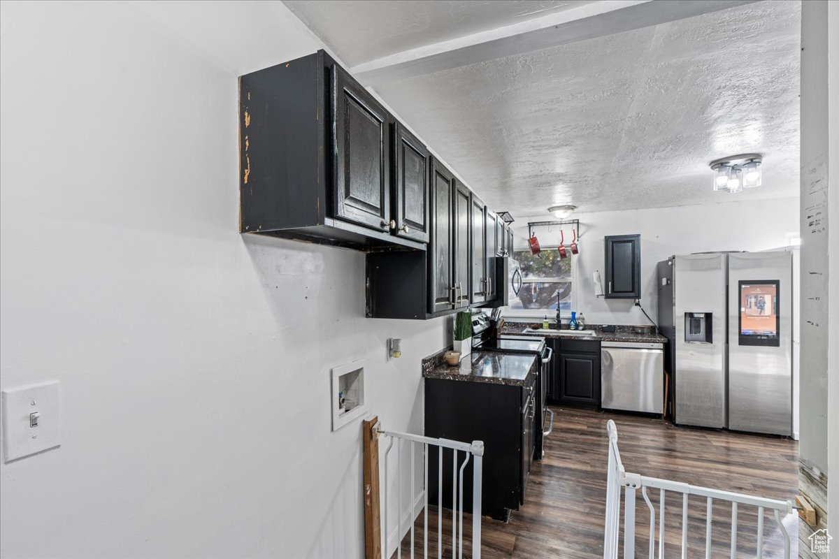 Kitchen with stainless steel appliances, sink, and dark hardwood / wood-style floors