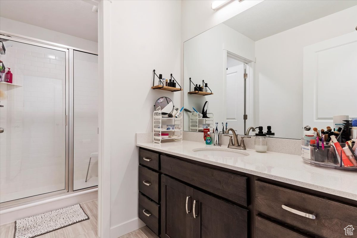 Bathroom with vanity, hardwood / wood-style floors, and an enclosed shower