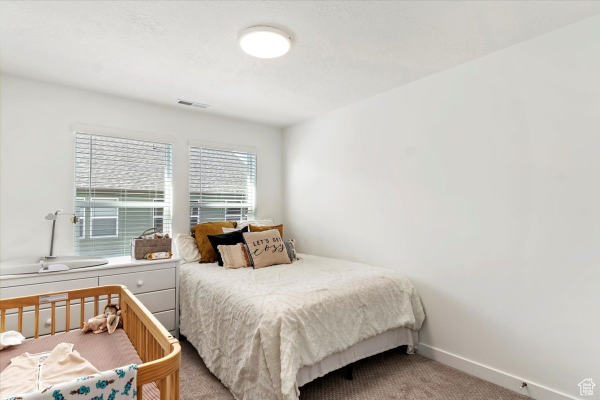 Bedroom featuring light colored carpet