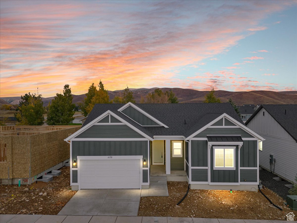 View of front of home with a mountain view and a garage