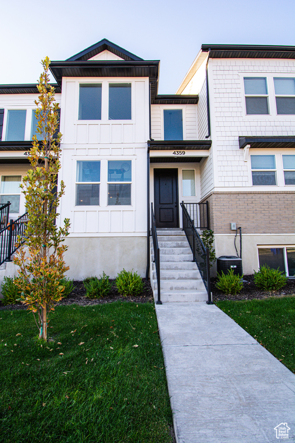 Townhome / multi-family property featuring a front yard