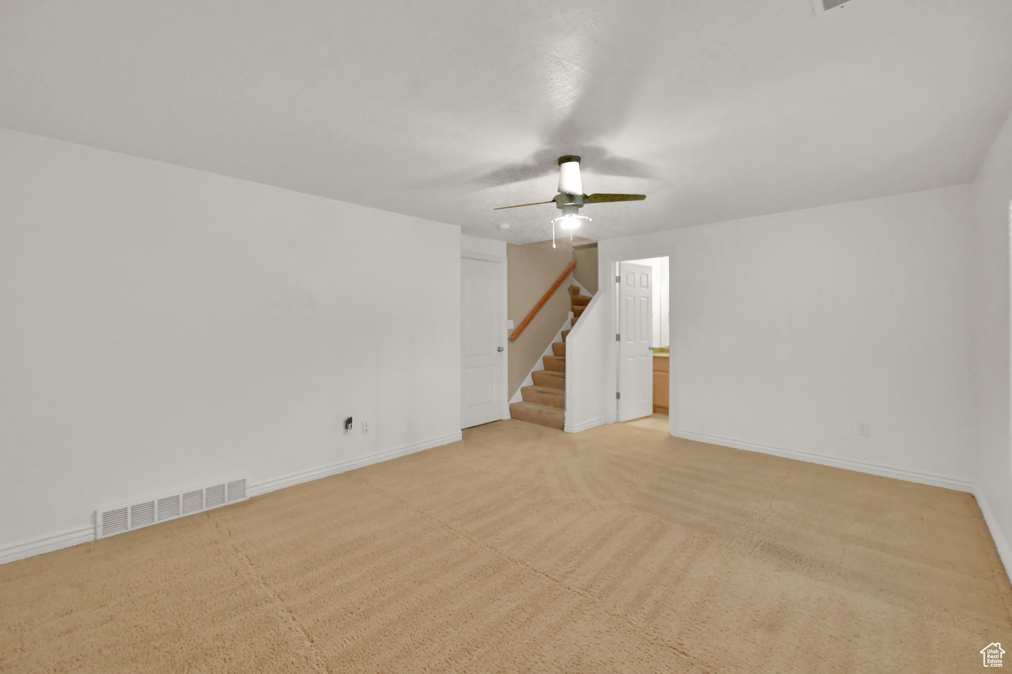 Unfurnished room with light carpet and ceiling fan