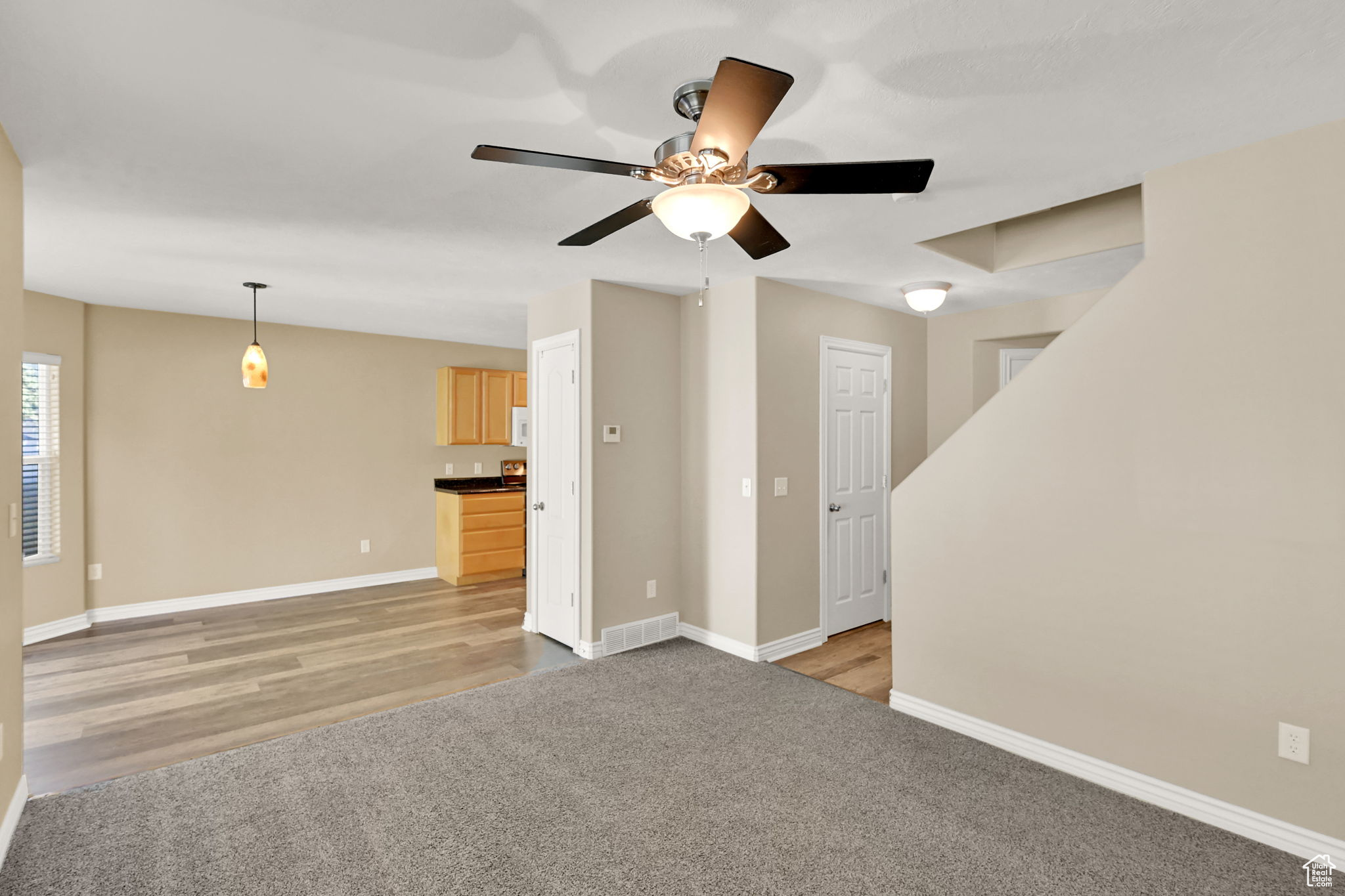 Unfurnished living room featuring light hardwood / wood-style flooring and ceiling fan