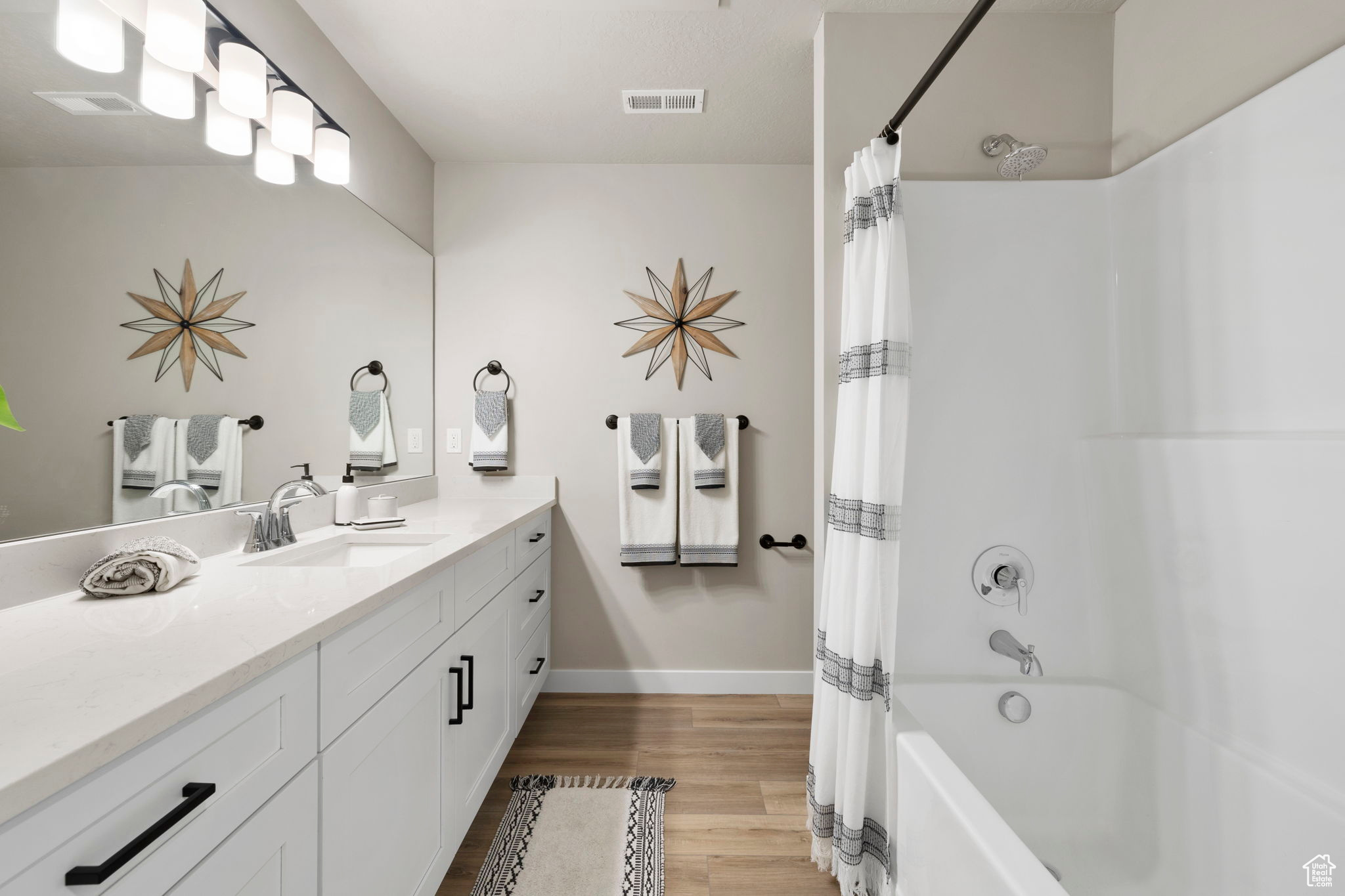 Bathroom with vanity, shower / bath combo, and hardwood / wood-style floors