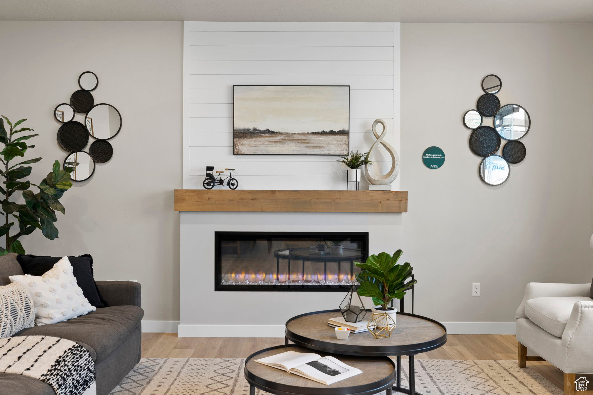 Living room with a large fireplace and light hardwood / wood-style floors