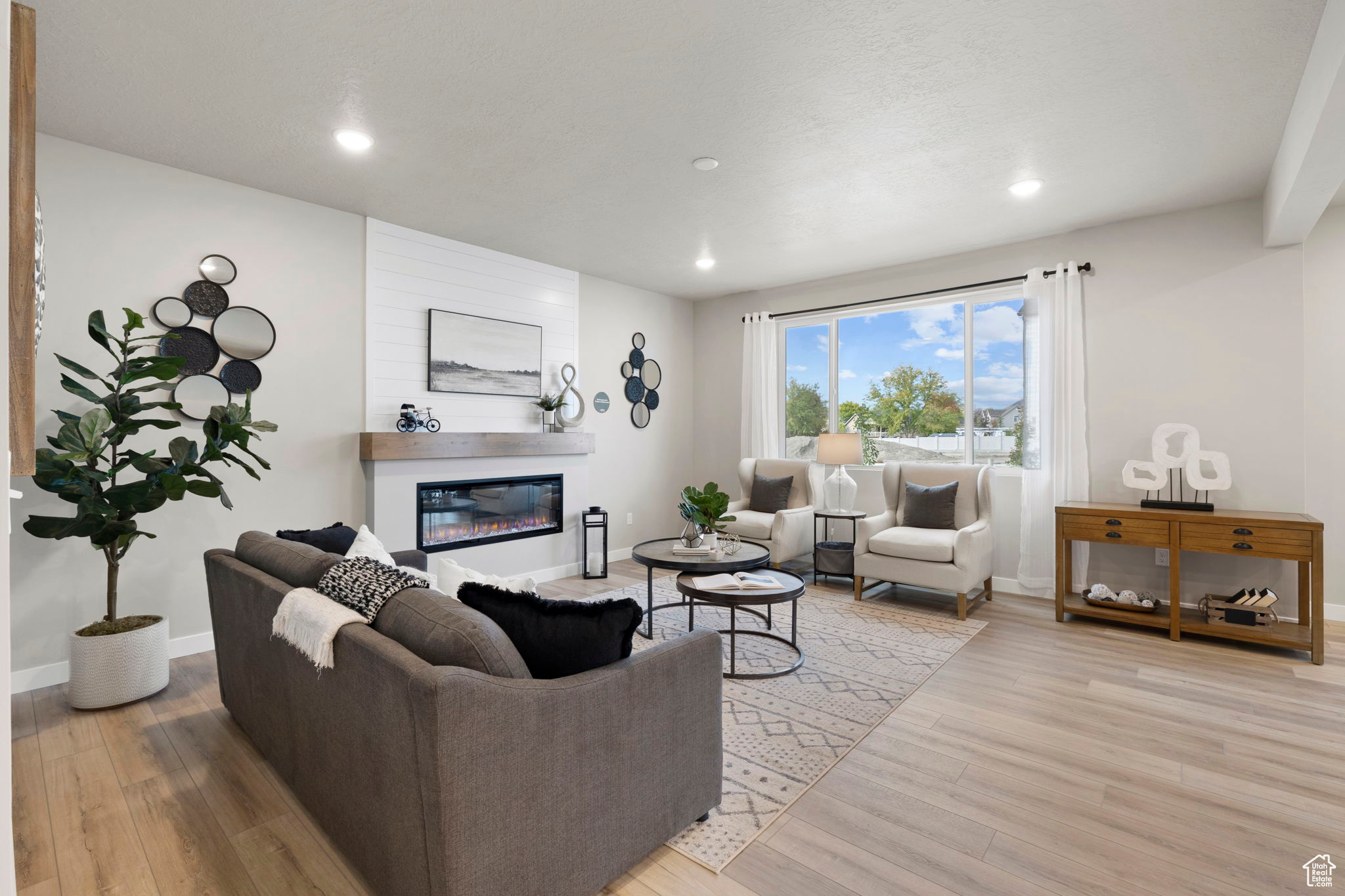 Living room with light hardwood / wood-style floors and a fireplace