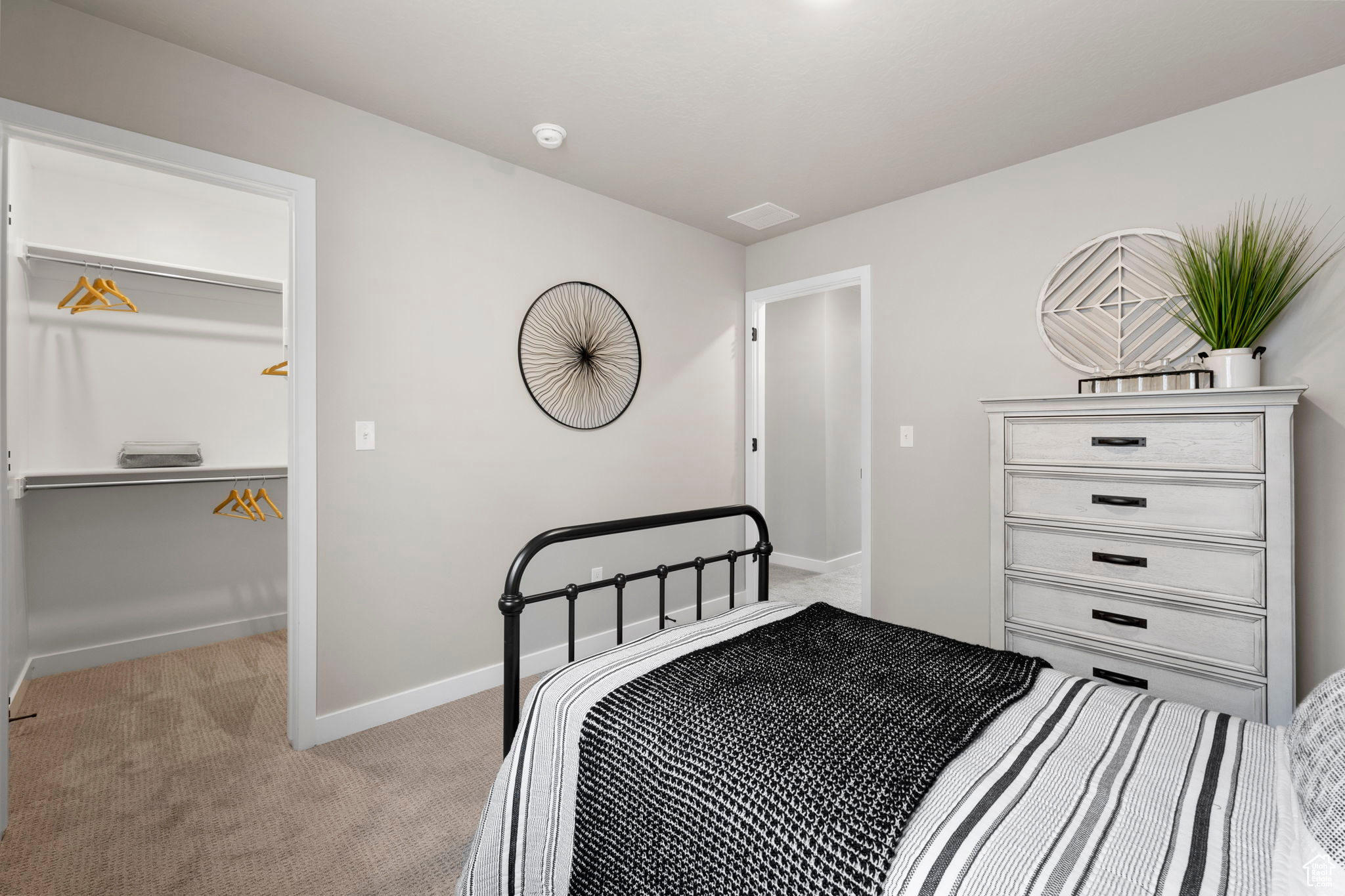 Carpeted bedroom featuring a spacious closet and a closet