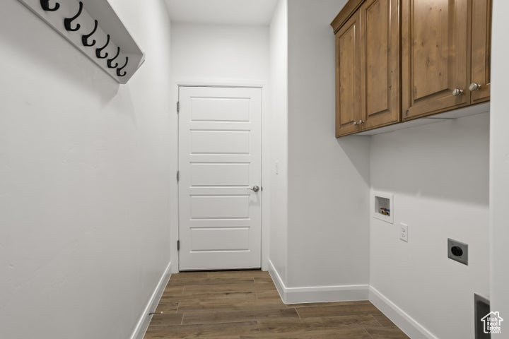 Laundry area with dark wood-type flooring, electric dryer hookup, washer hookup, and cabinets