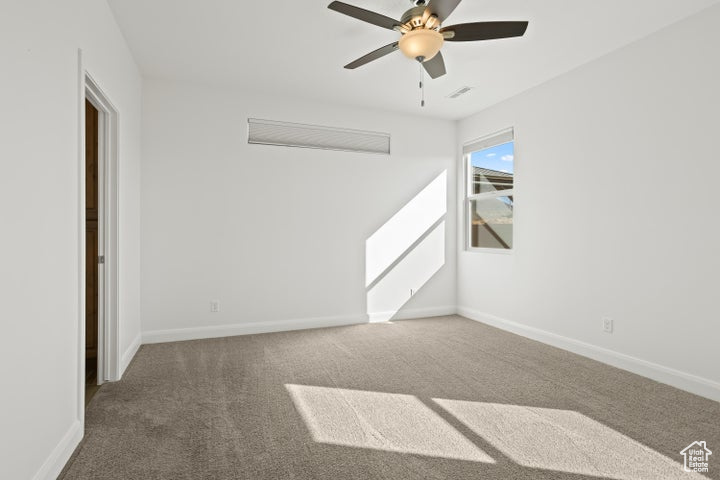 Unfurnished room featuring carpet flooring and ceiling fan