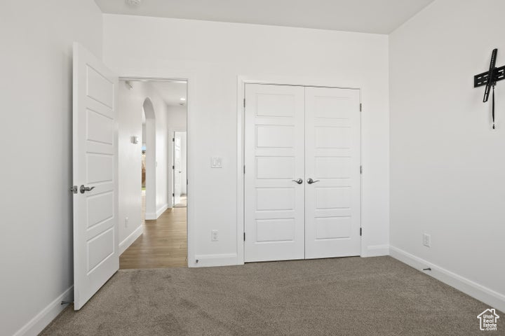 Unfurnished bedroom featuring carpet and a closet