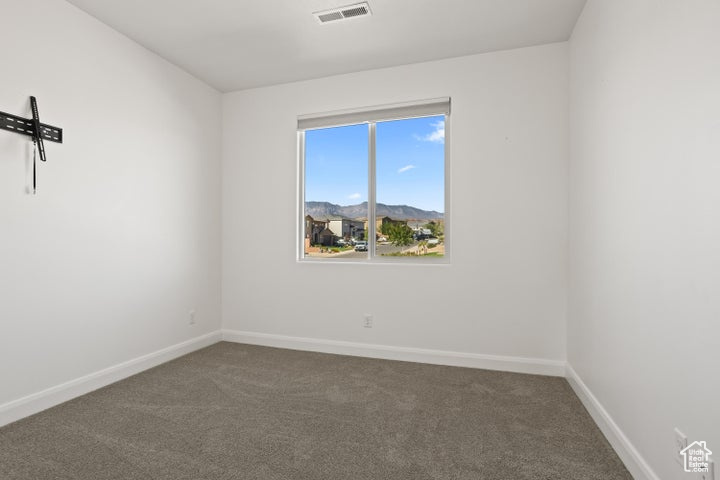 Empty room with a mountain view and carpet floors