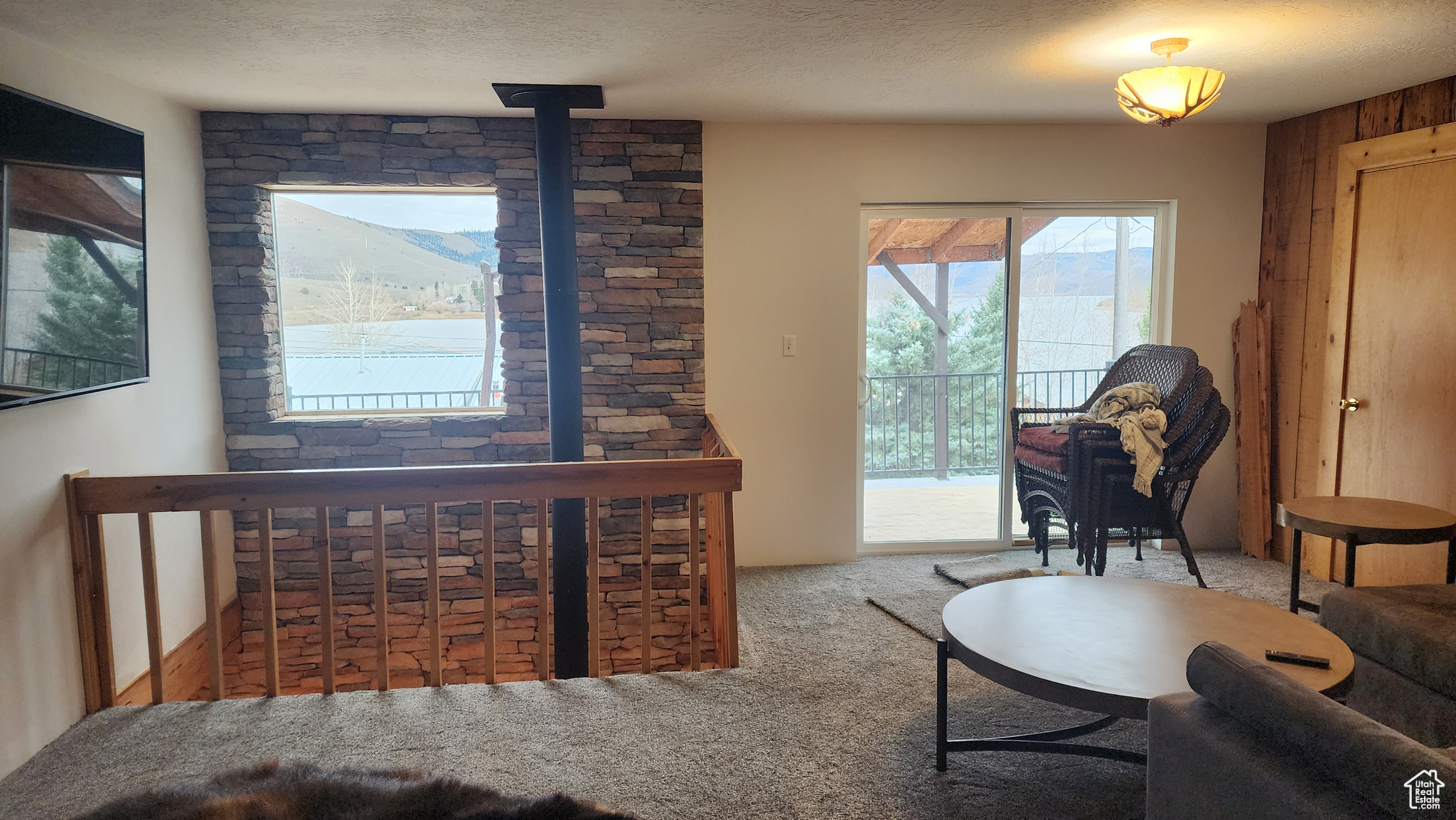 Carpeted living room with wood walls and a textured ceiling