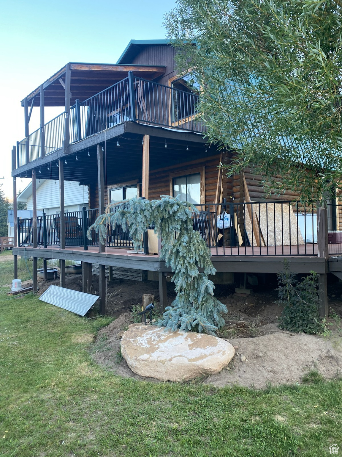 Back of house featuring a wooden deck and a lawn