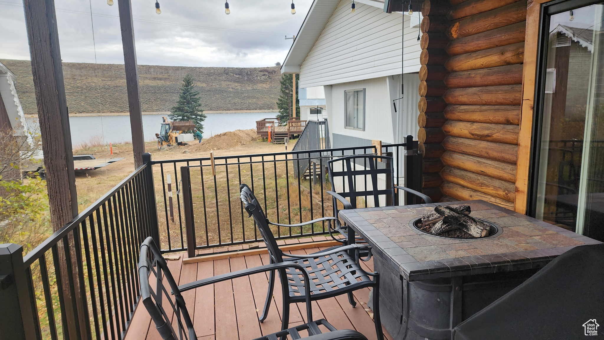 Wooden deck with an outdoor fire pit and a water view