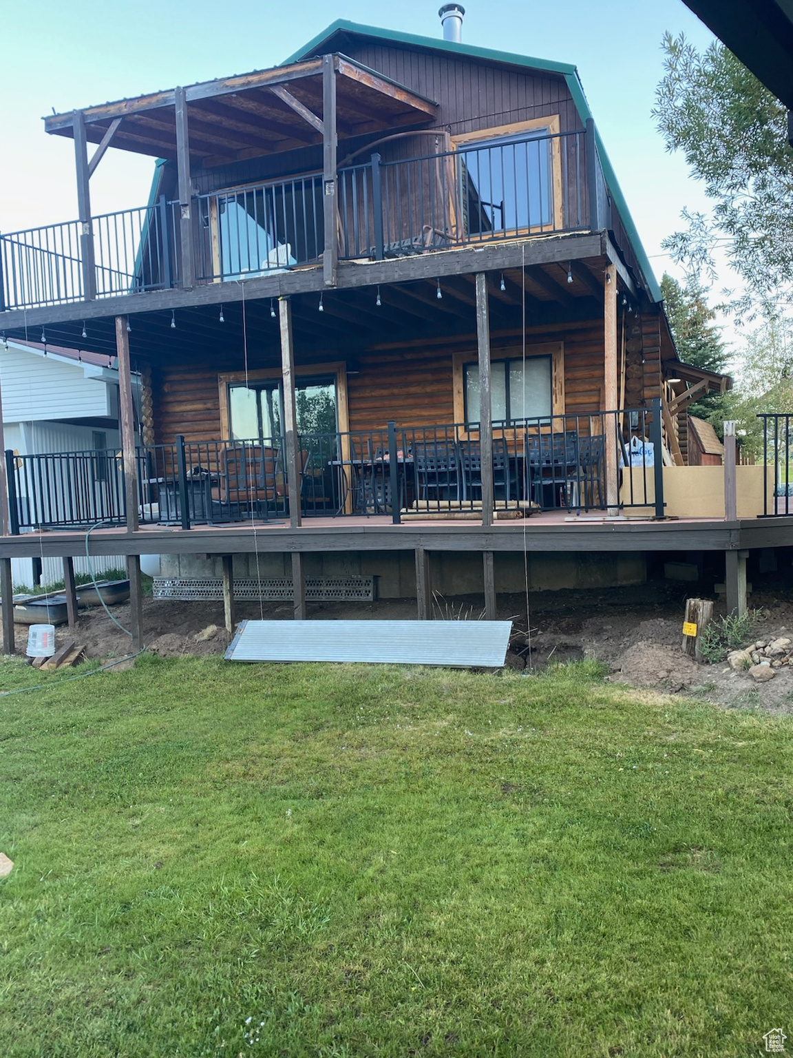 Rear view of property featuring a deck and a lawn