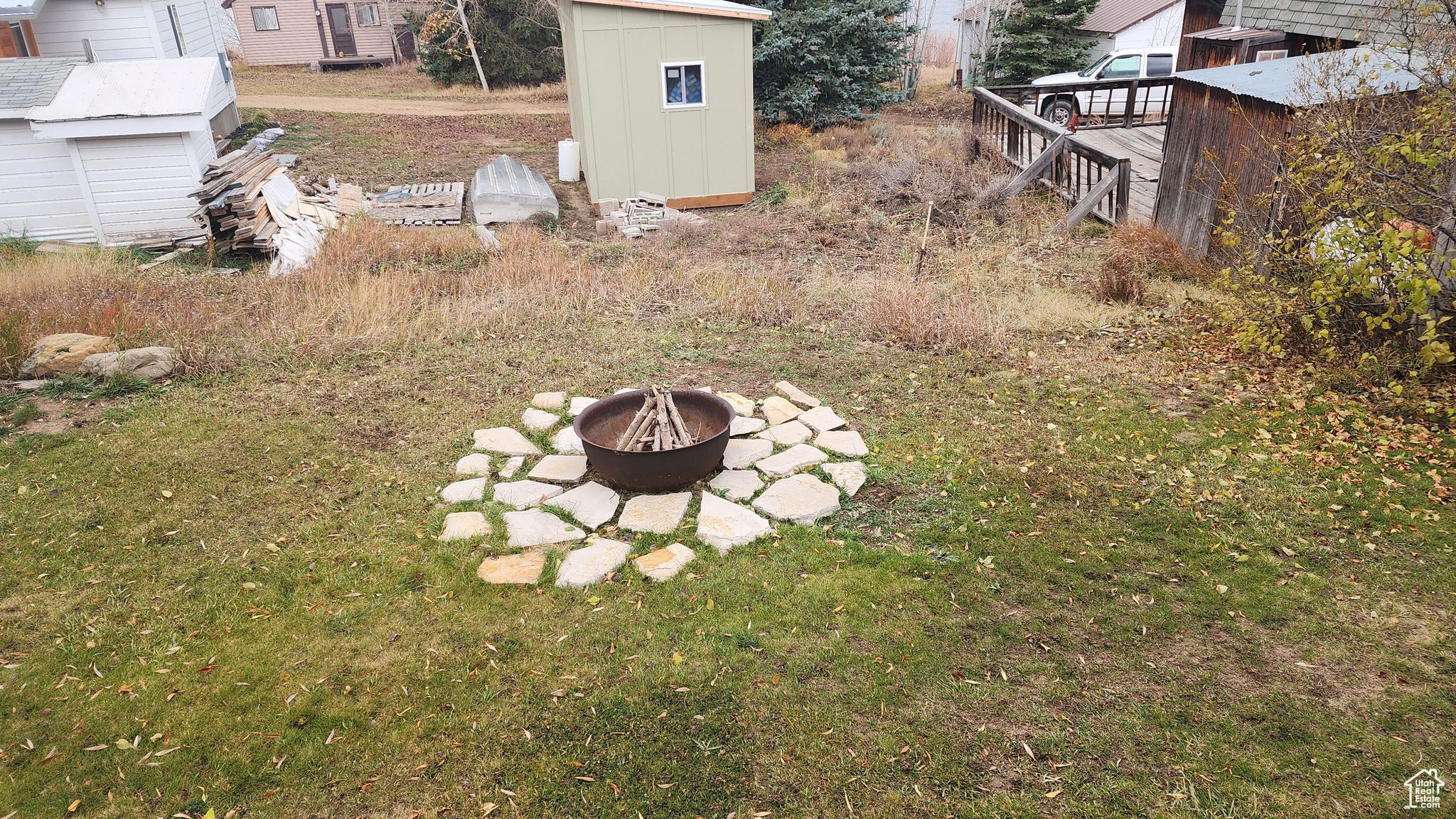 View of yard featuring a storage shed, a deck, and a fire pit