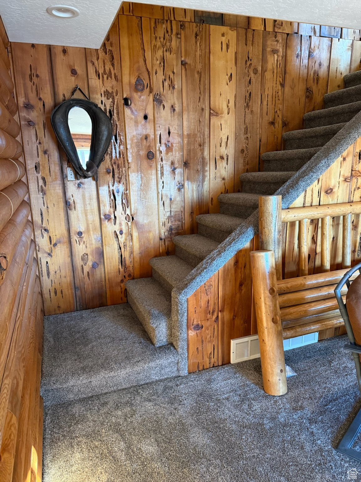 Stairway with a textured ceiling and carpet floors