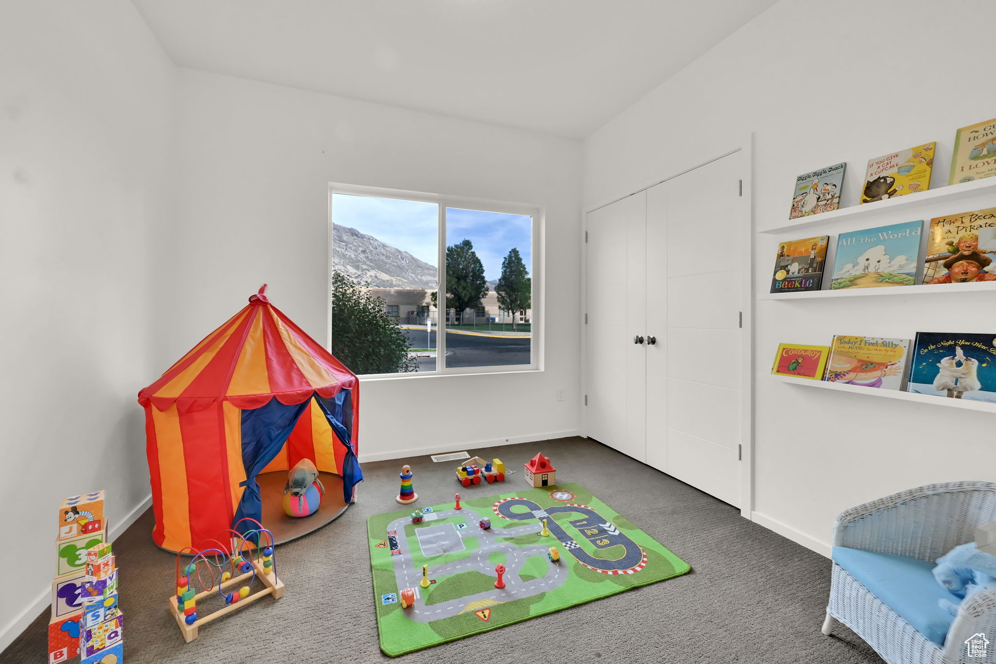 Rec room with a mountain view and dark colored carpet