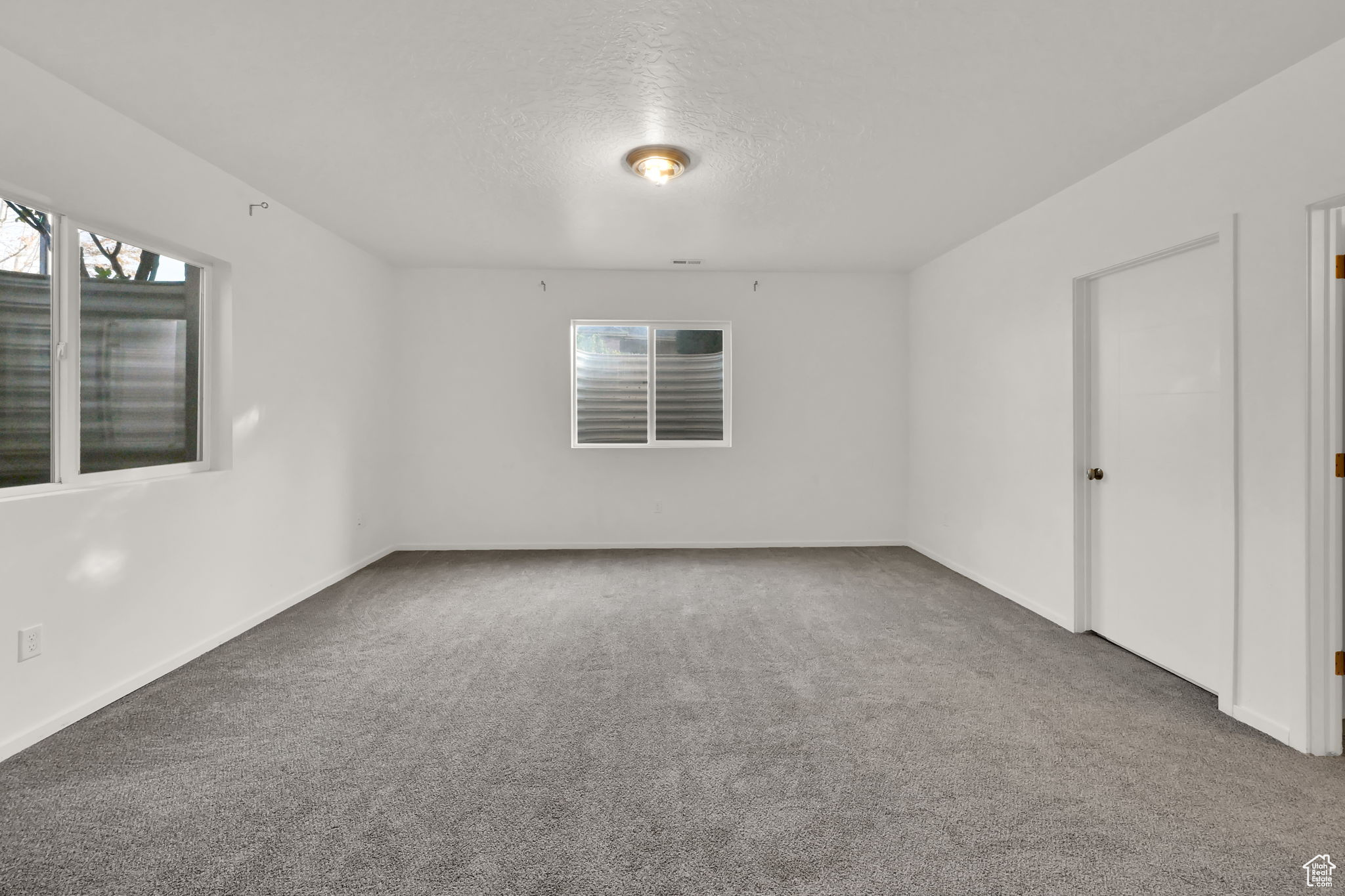 Empty room with carpet and a textured ceiling