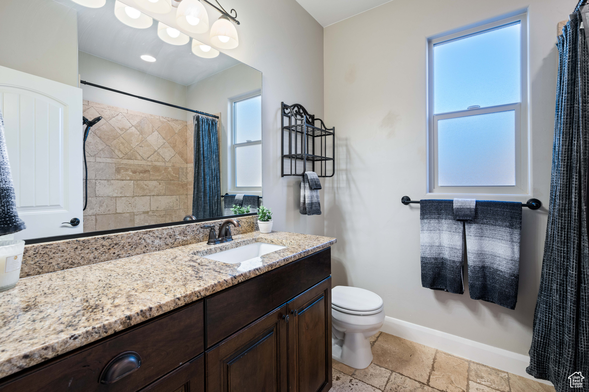 Bathroom with toilet, walk in shower, and vanity