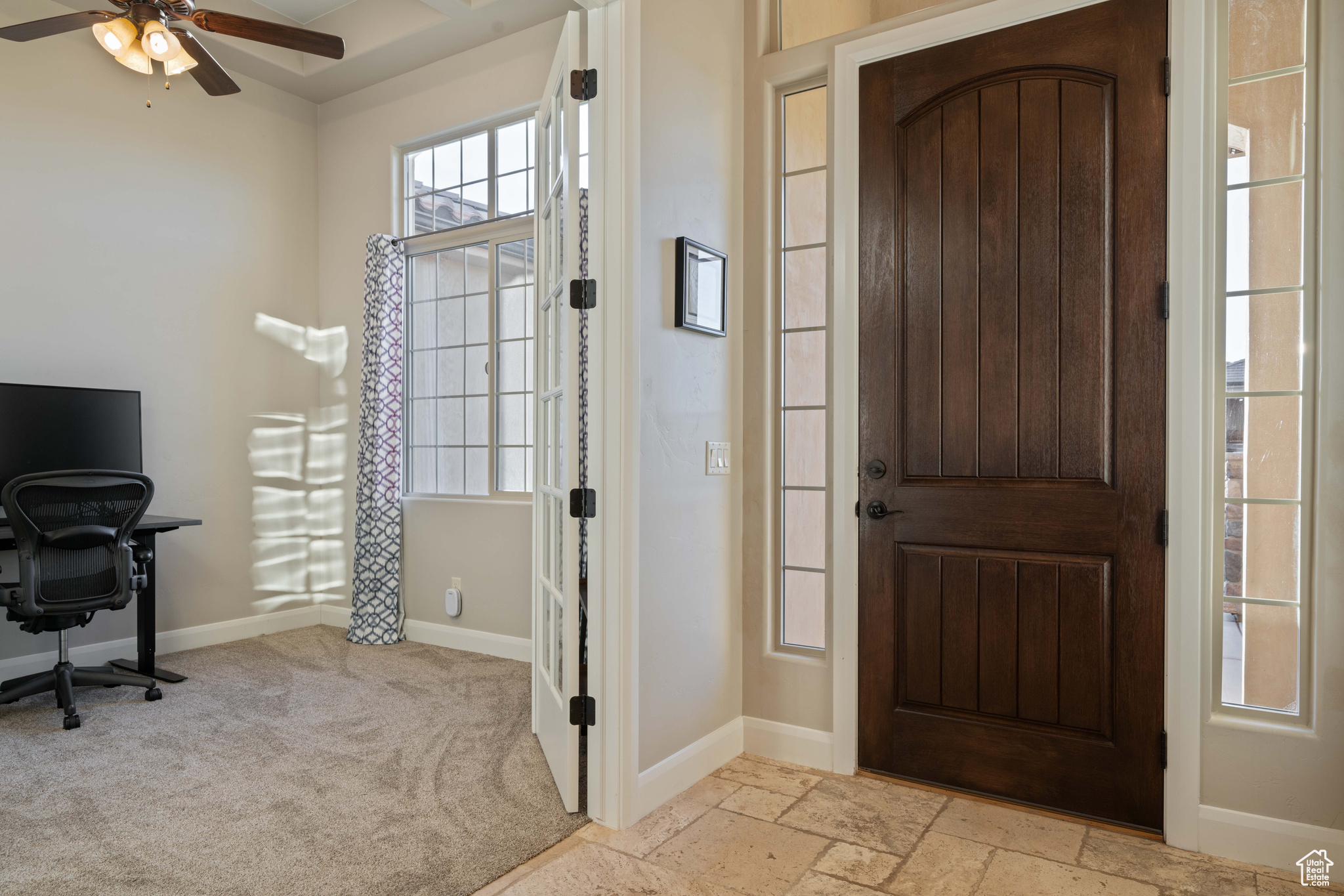 Entrance foyer with light carpet and ceiling fan