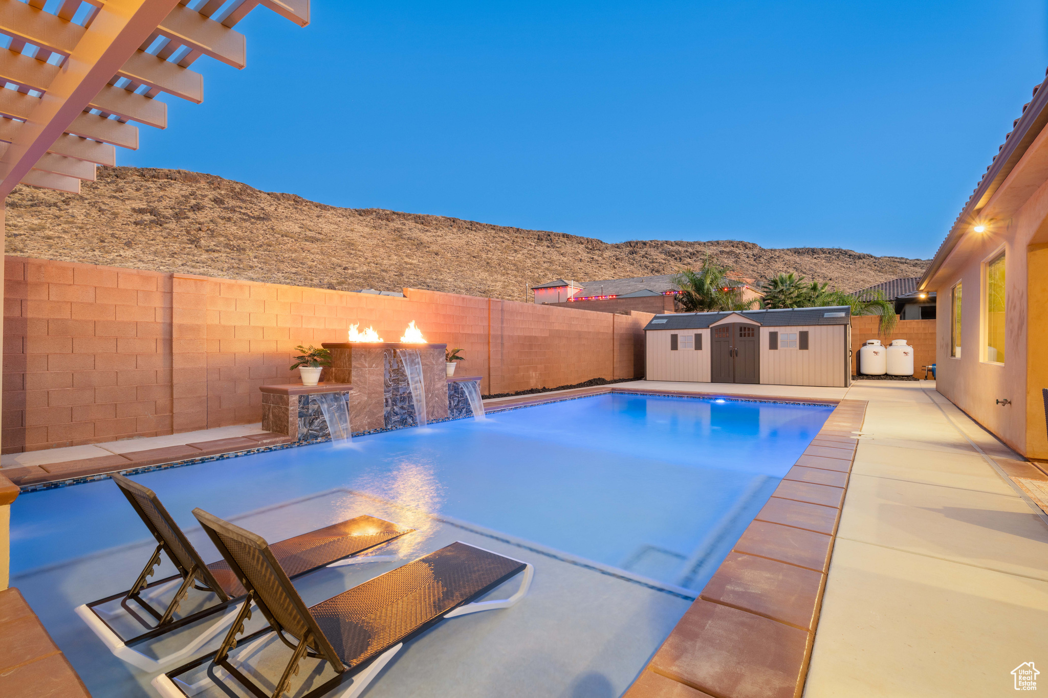 View of pool with a shed, a patio area, a mountain view, and pool water feature