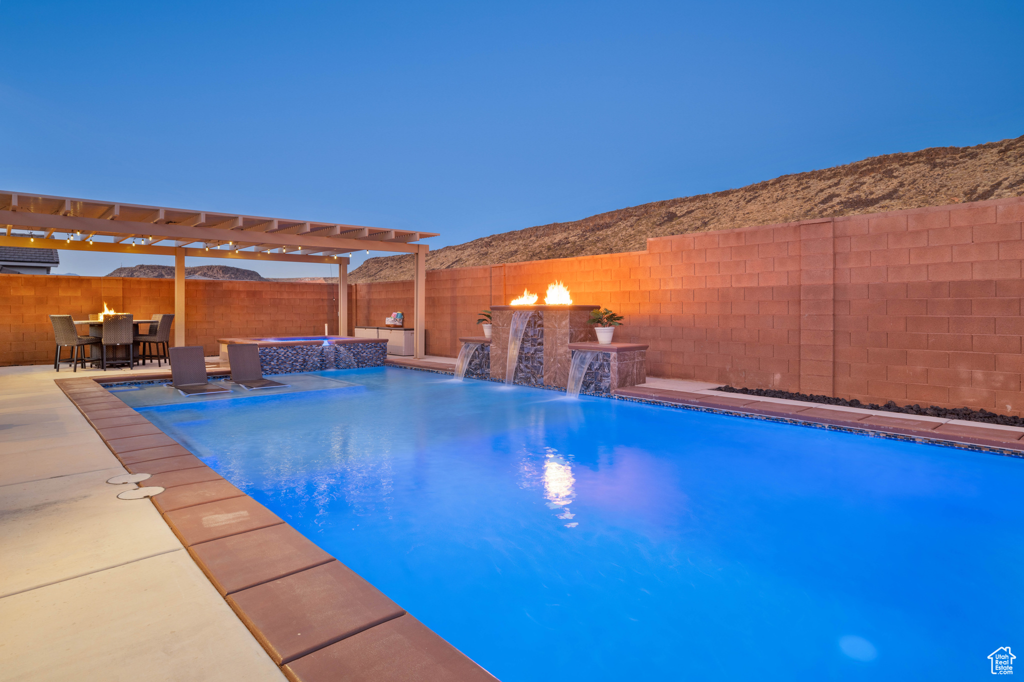 View of pool with an in ground hot tub, a patio, an AC wall unit, a pergola, and pool water feature