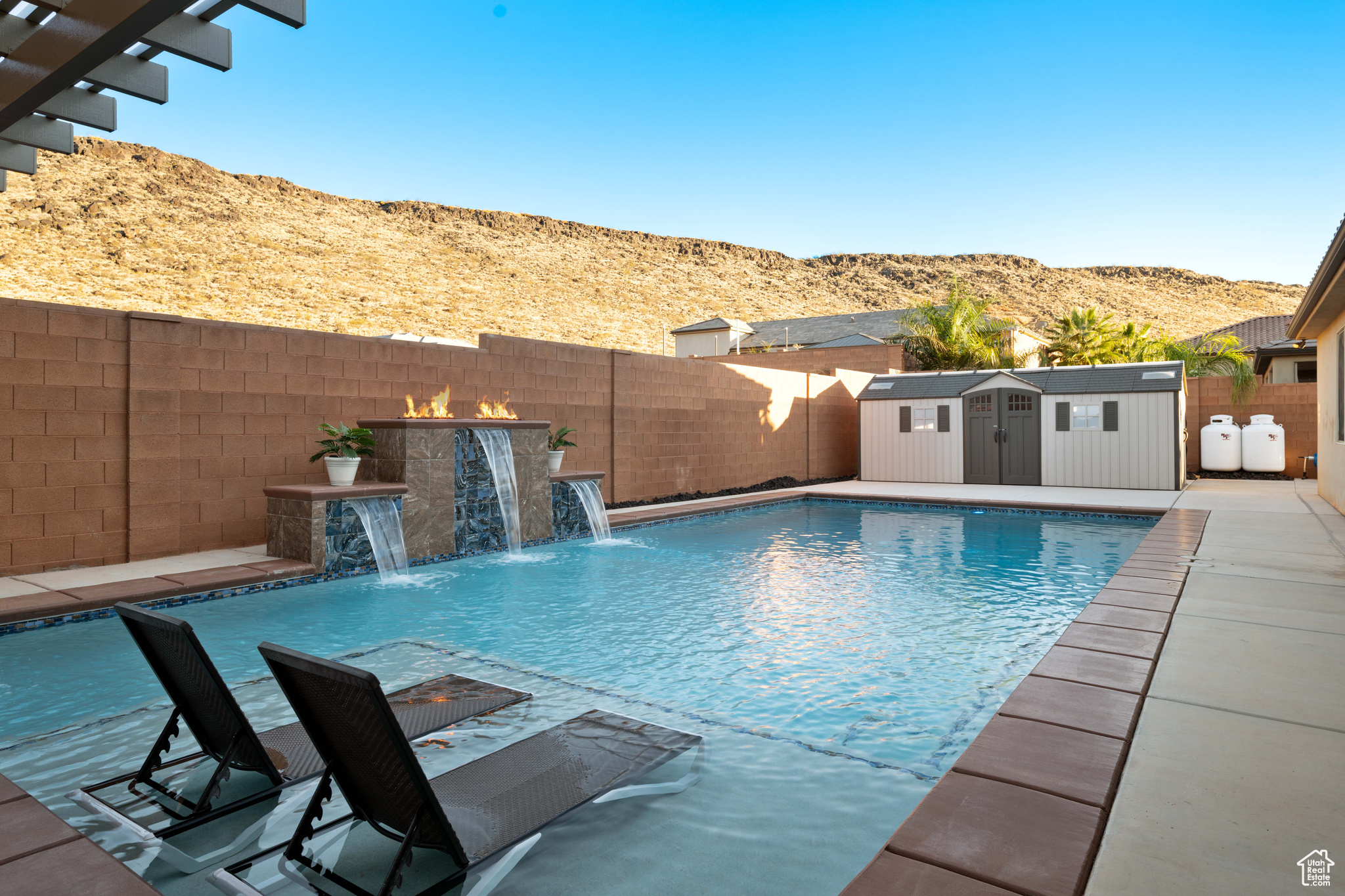 View of swimming pool featuring a storage unit, a mountain view, and pool water feature