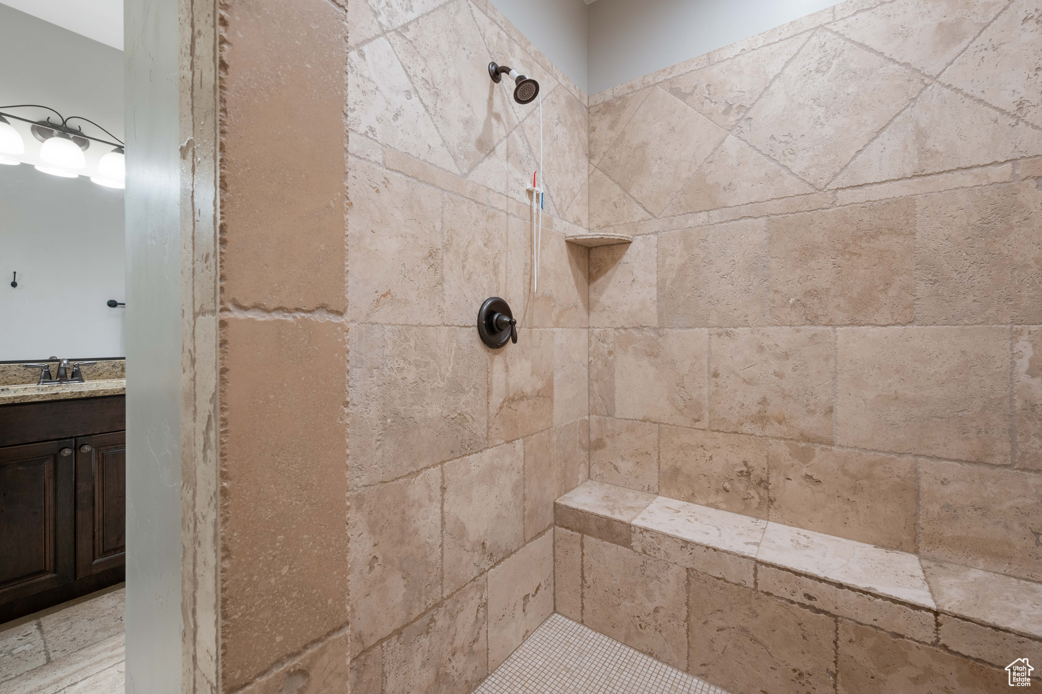 Bathroom with vanity and tiled shower