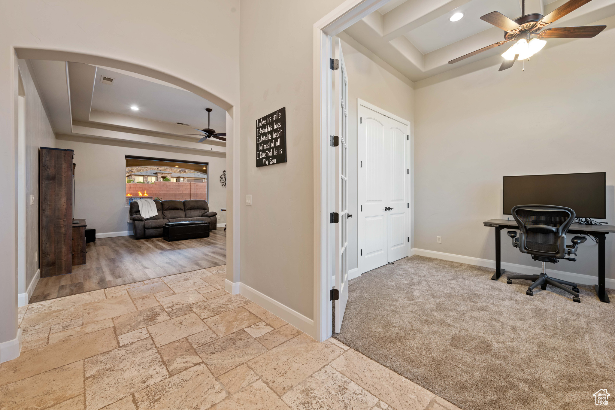 Office space featuring a tray ceiling and ceiling fan