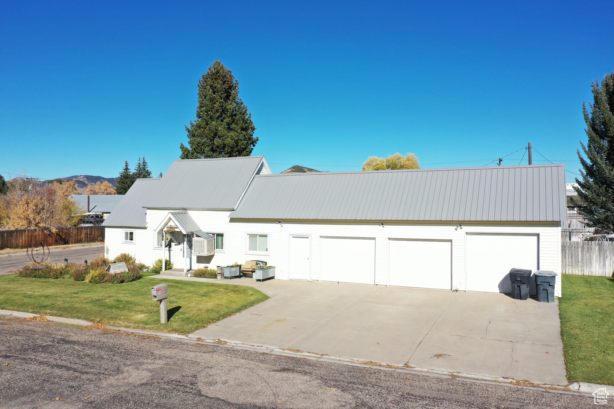 View of front of house with a front yard, a garage, and cooling unit