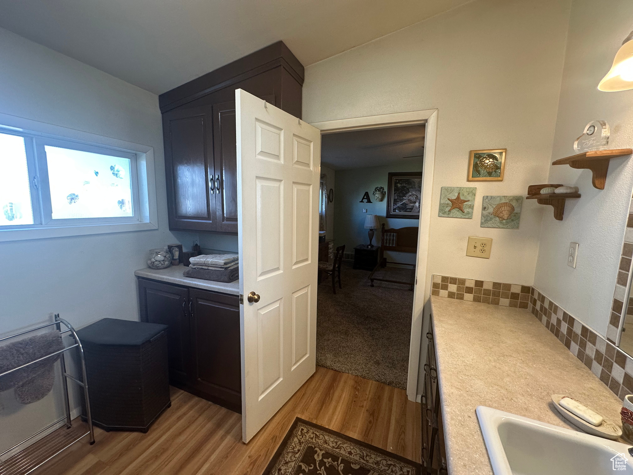 Clothes washing area featuring sink and light hardwood / wood-style floors