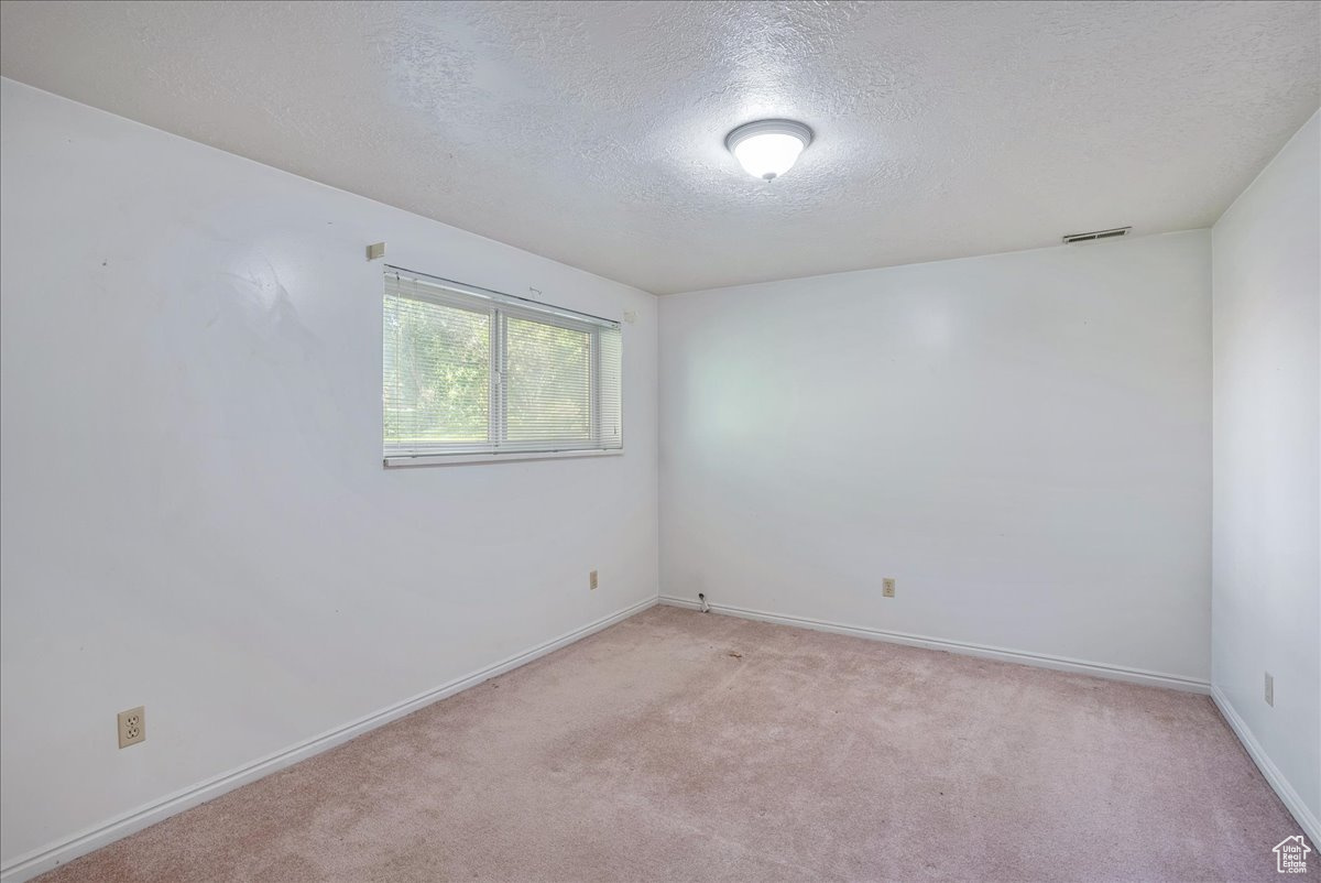 Carpeted empty room featuring a textured ceiling