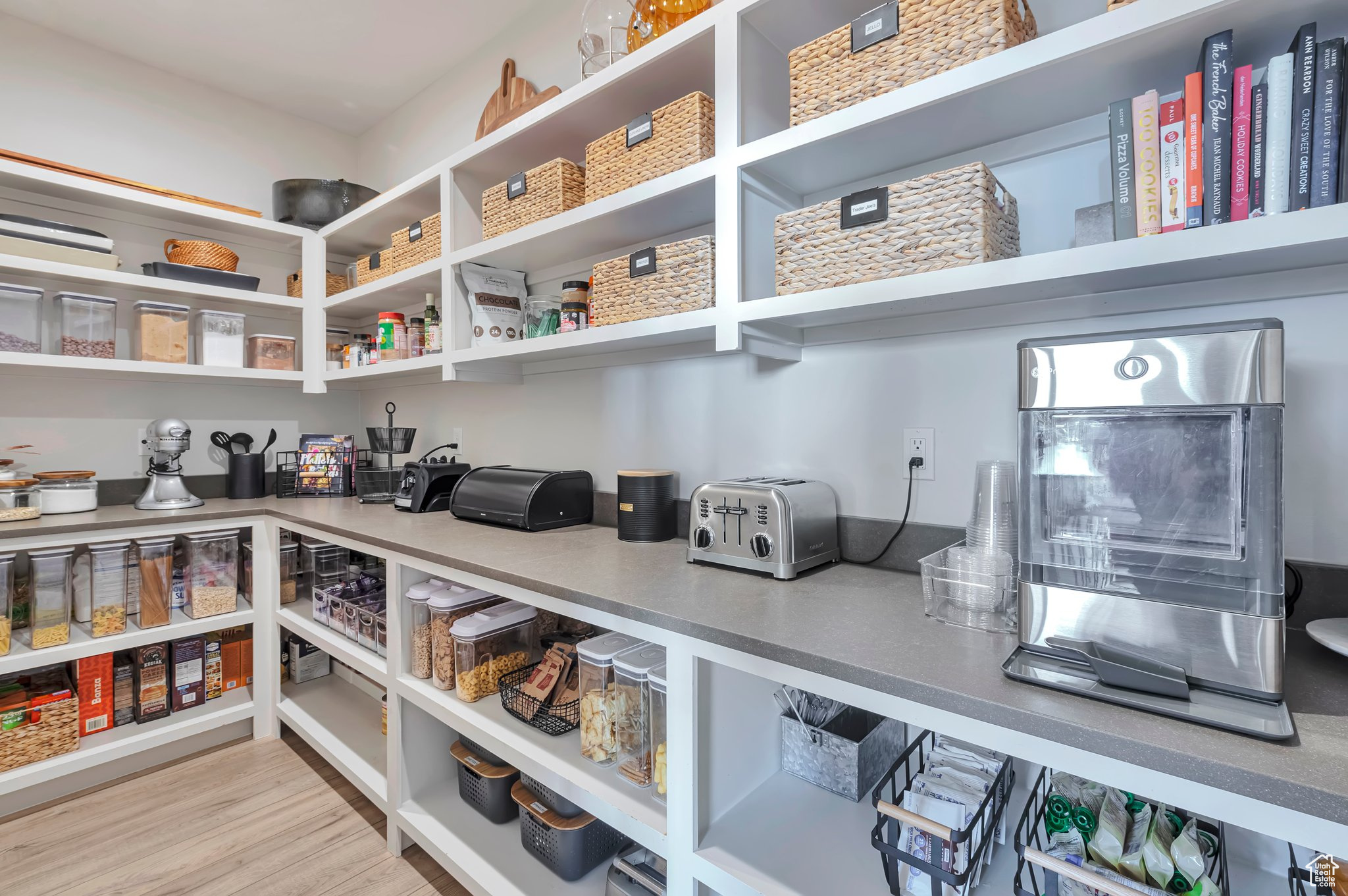 View of Butlers Pantry. Pantry includes Quartz, Outlets, Face Framed Shelving, and Outlets. Pantry has a False Cabinent door for high quality concealed entry.