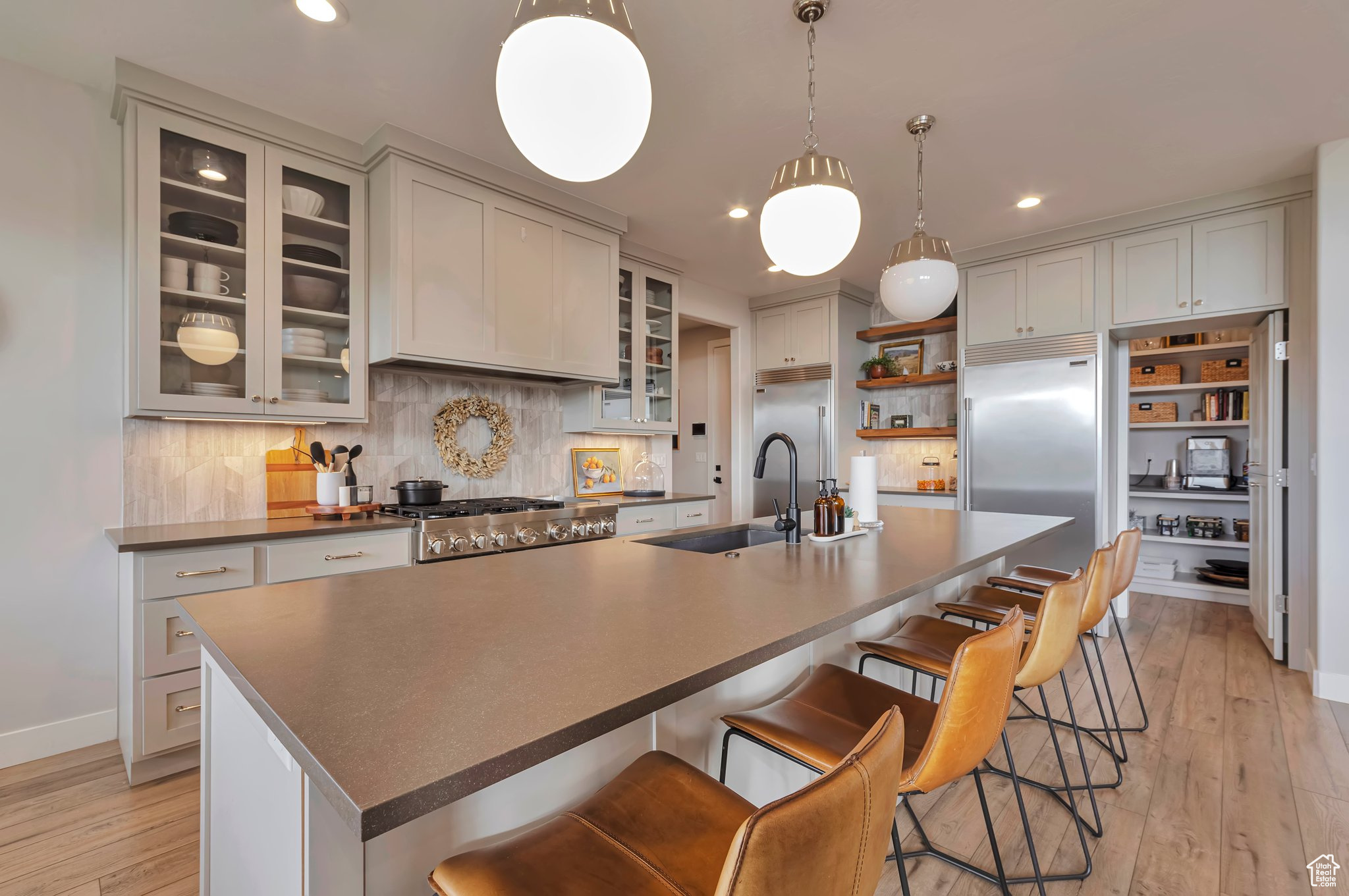 Kitchen featuring a breakfast bar, a kitchen island with sink, sink, and light wood-type flooring