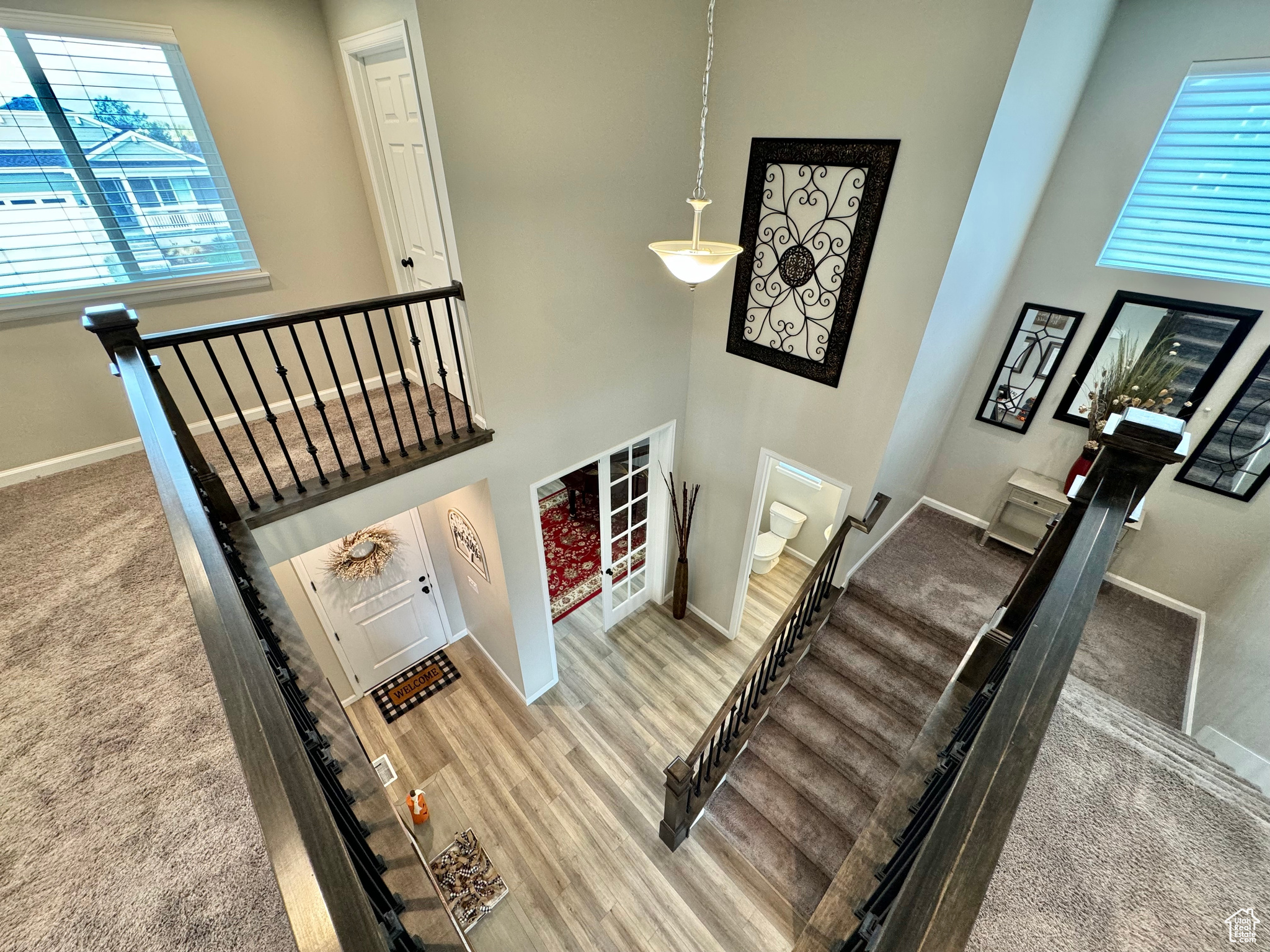 Stairway with a wealth of natural light, hardwood / wood-style flooring, and a towering ceiling