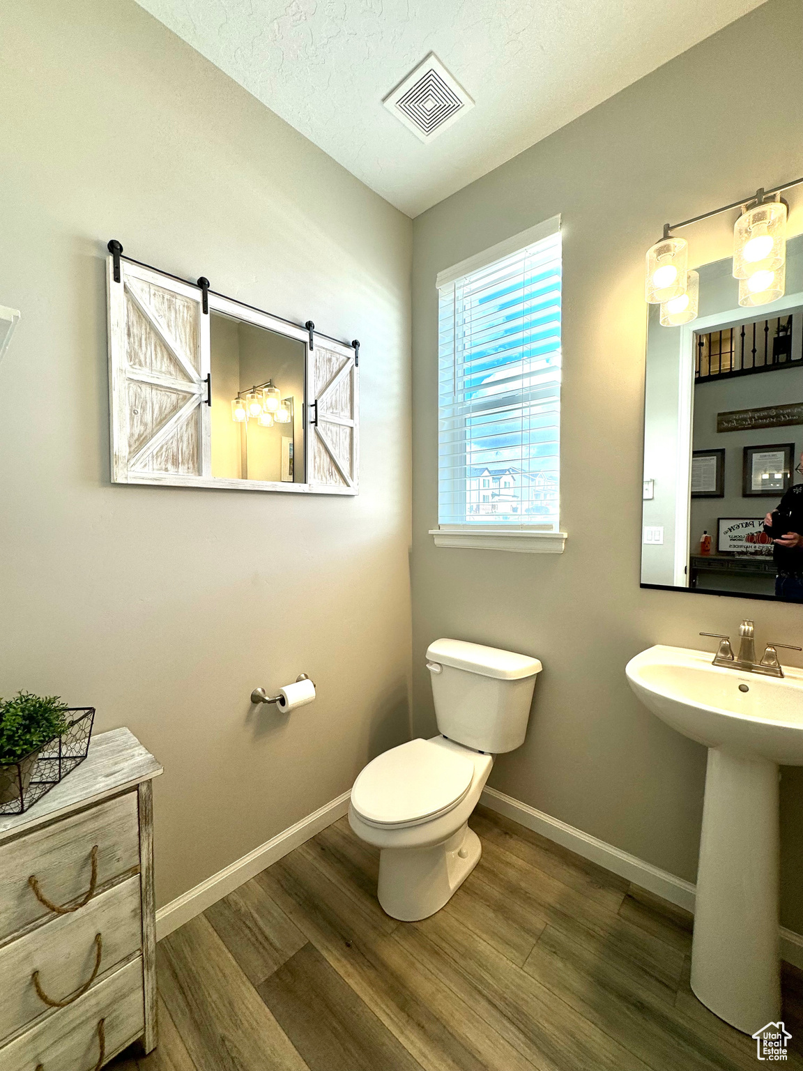 Main Floor Half Bath featuring sink, toilet, wood-type flooring, and a textured ceiling