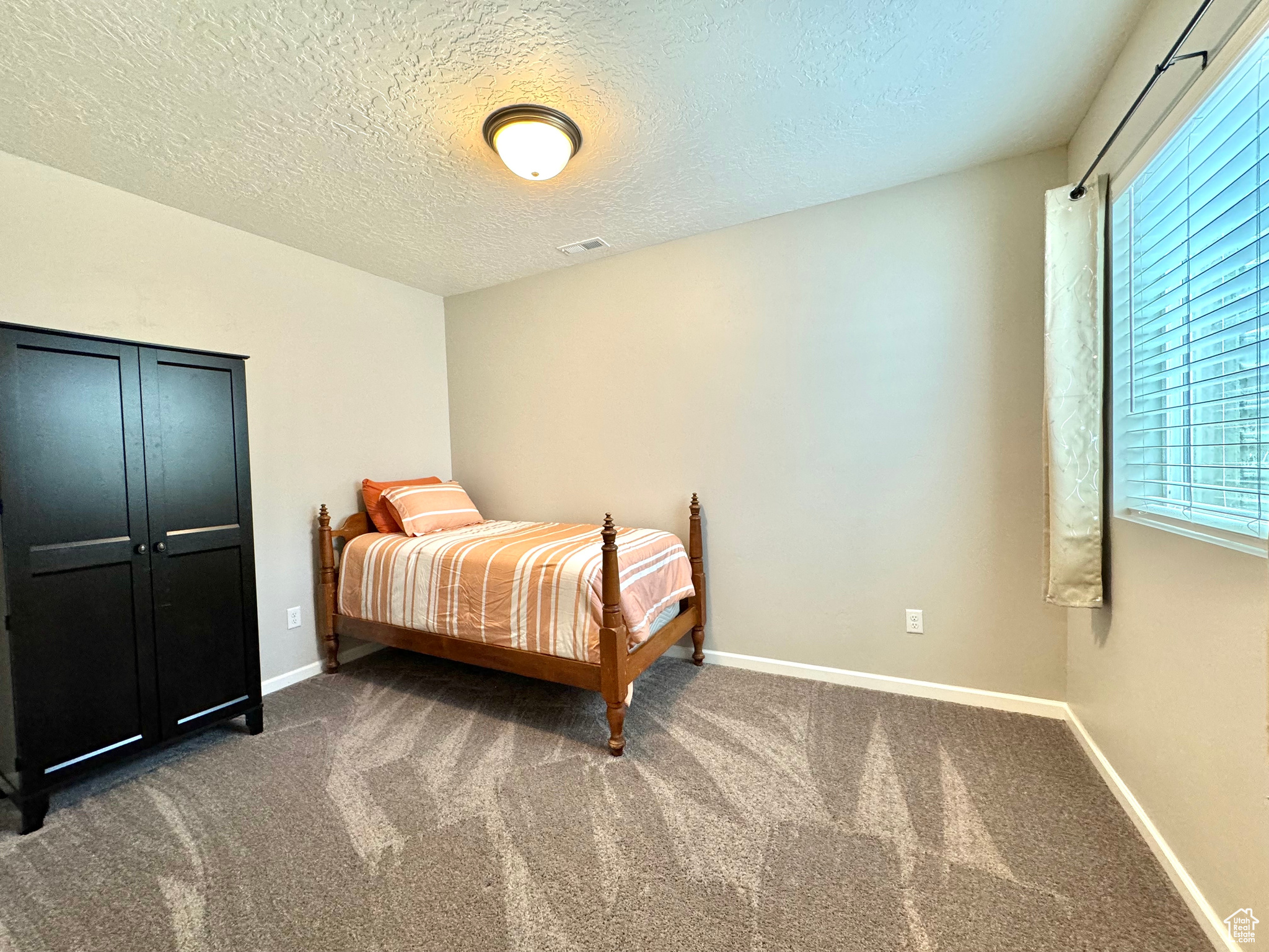 Basement Bedroom featuring a textured ceiling and carpet flooring