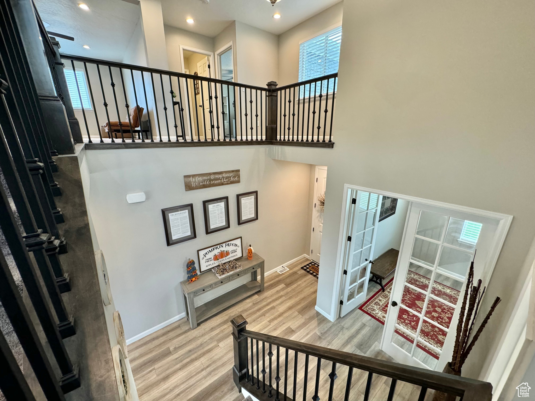 Beautiful Staircase featuring a towering ceiling, french doors, and hardwood / wood-style floors