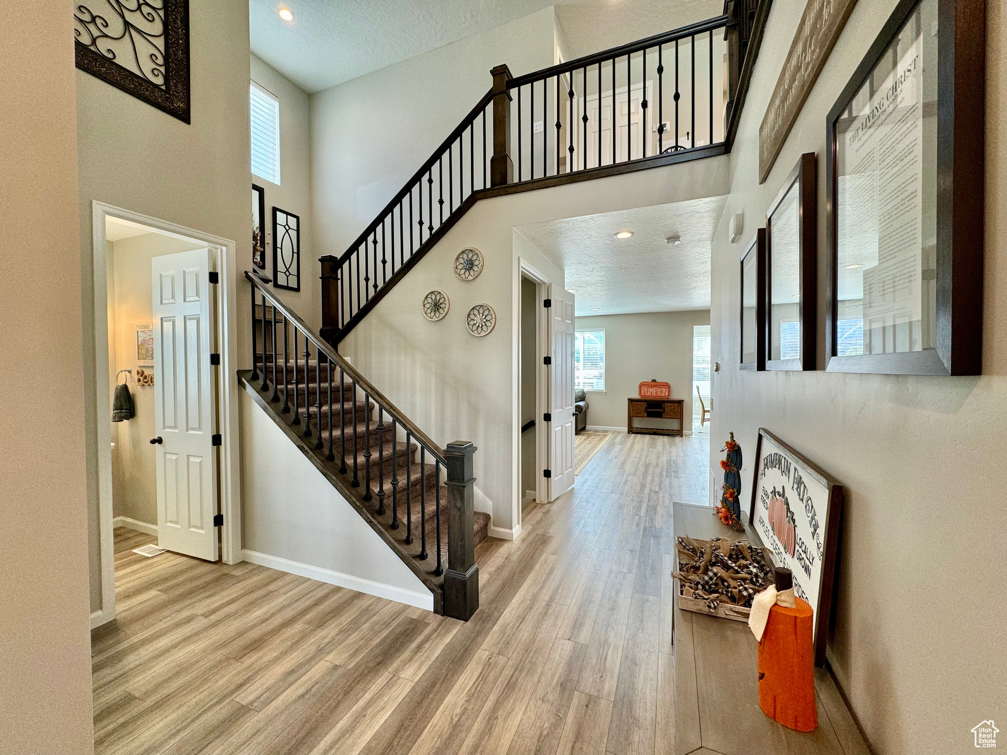 Interior space with light hardwood / wood-style floors, a healthy amount of sunlight, and a high ceiling