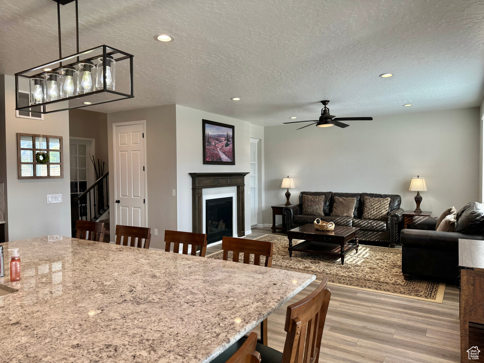 Kitchen/Living Room. Interior space featuring light hardwood / wood-style floors, a textured ceiling, and ceiling fan