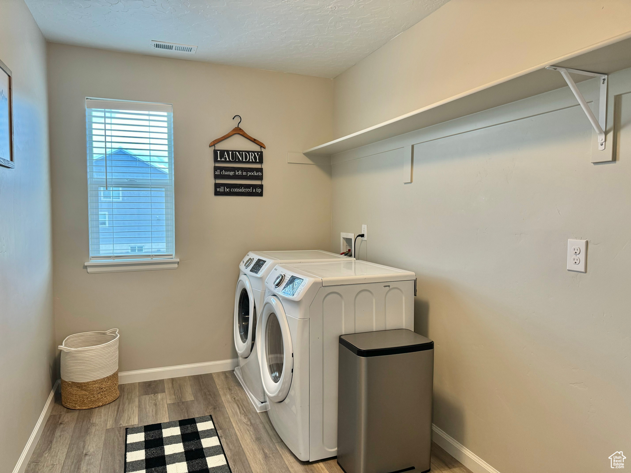 Upstairs Laundry room featuring light hardwood / wood-style floors, a textured ceiling, and separate washer and dryer