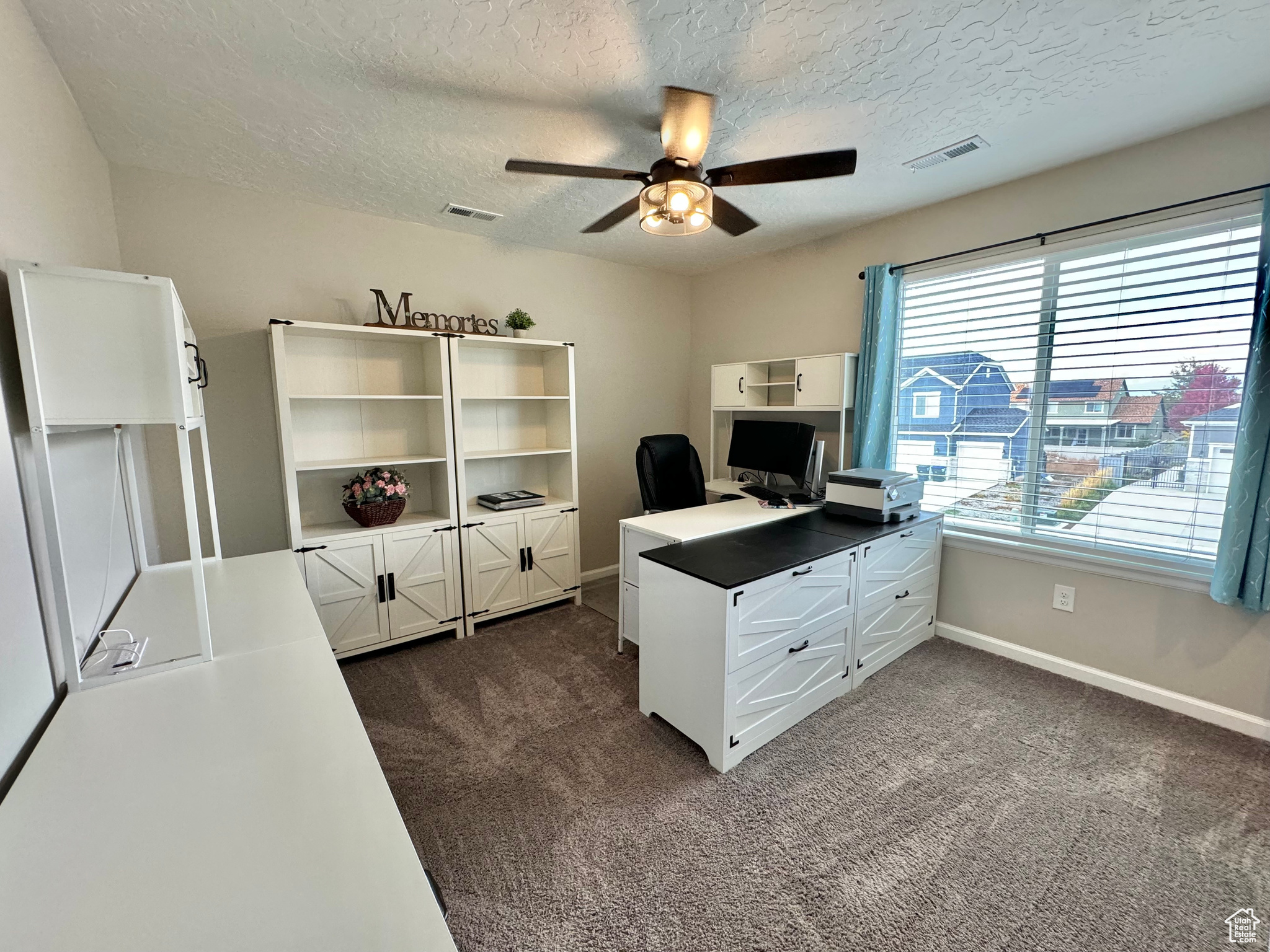 Upstairs Office/Bed Room area featuring a textured ceiling, dark carpet, and ceiling fan