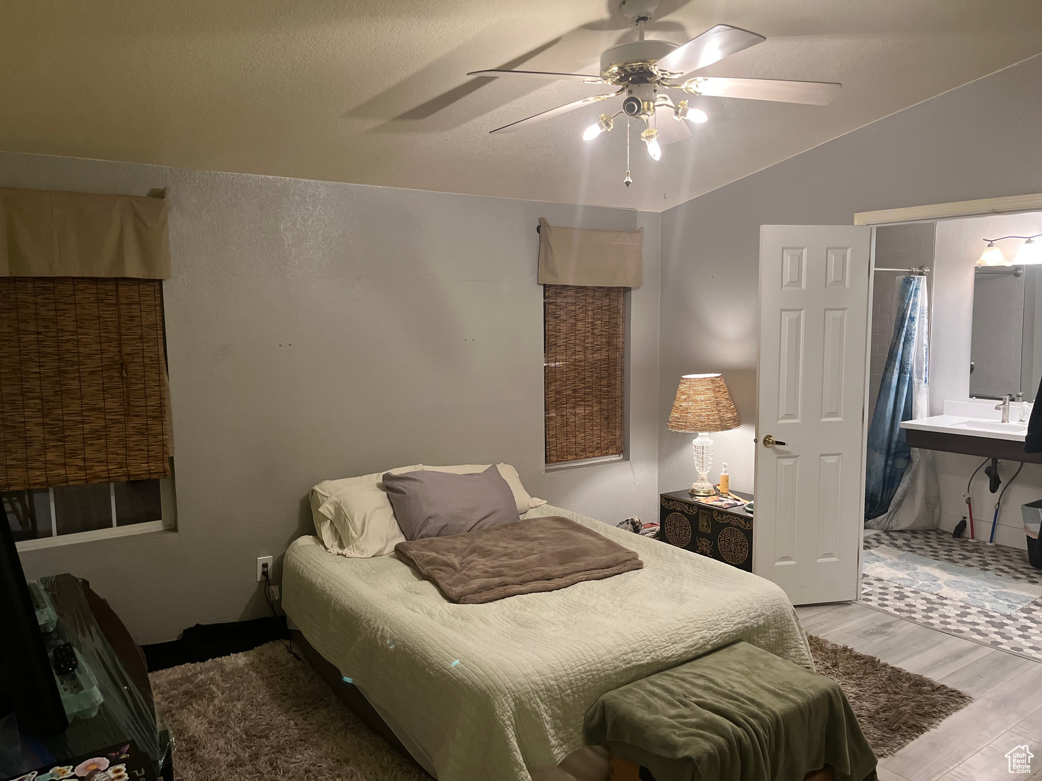 Bedroom with hardwood / wood-style floors, ceiling fan, lofted ceiling, and ensuite bath