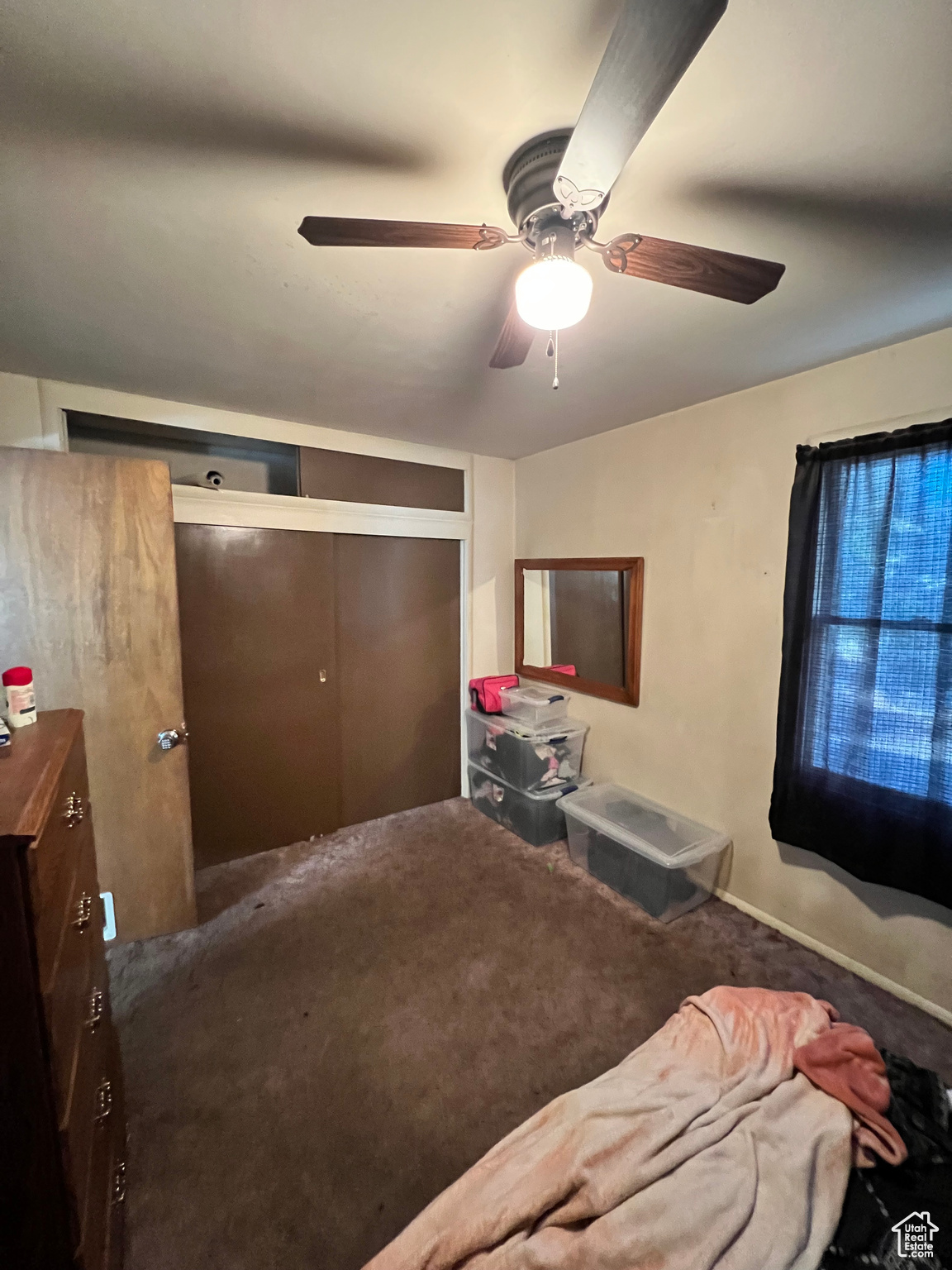 Carpeted bedroom featuring a closet and ceiling fan